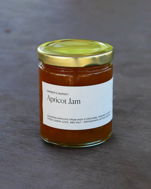 Jar of Farmer's Market Apricot Jam with a gold lid on a gray background.